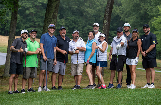 A group of golfers smiling at the camera