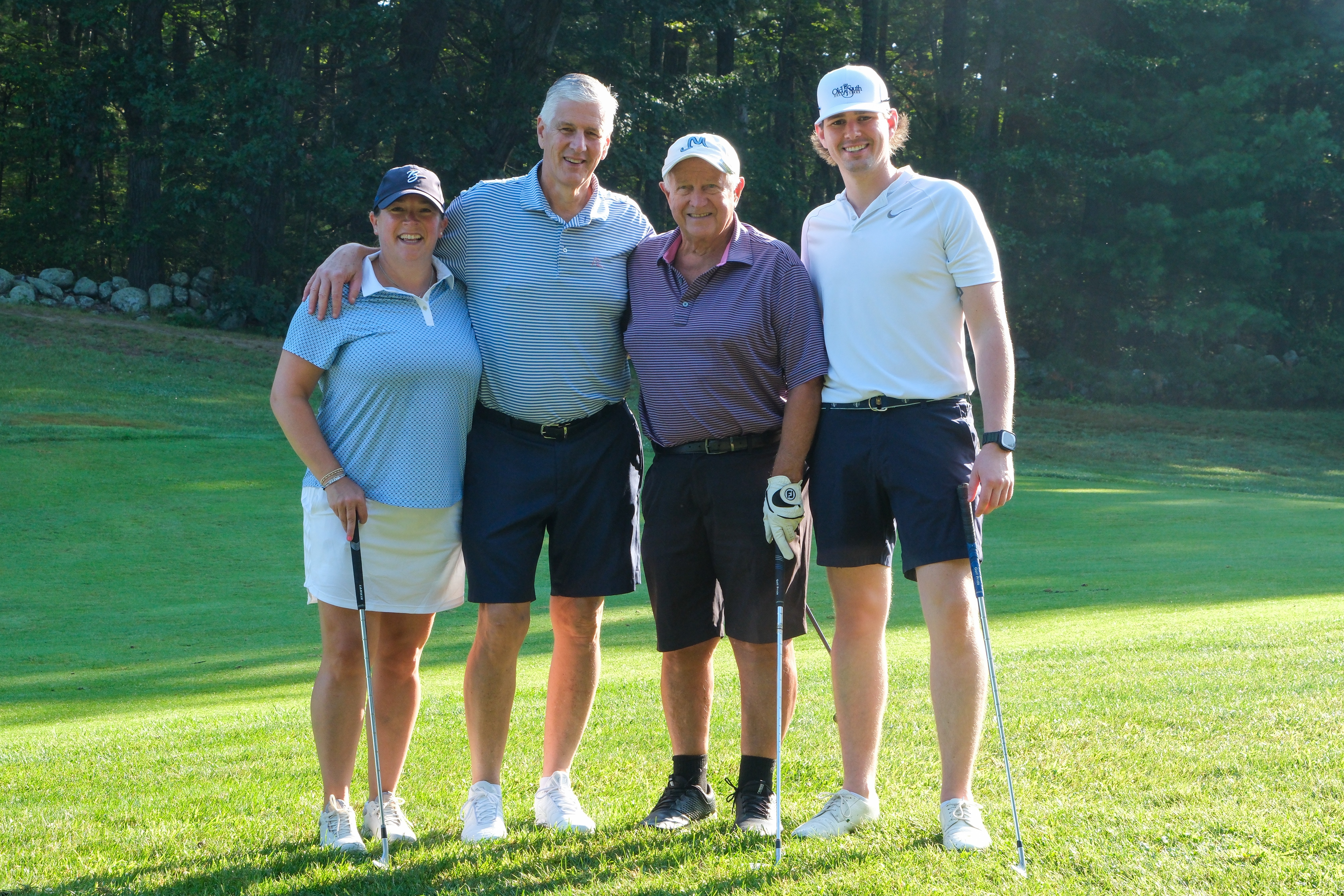 A group of golfers smiling at the camera
